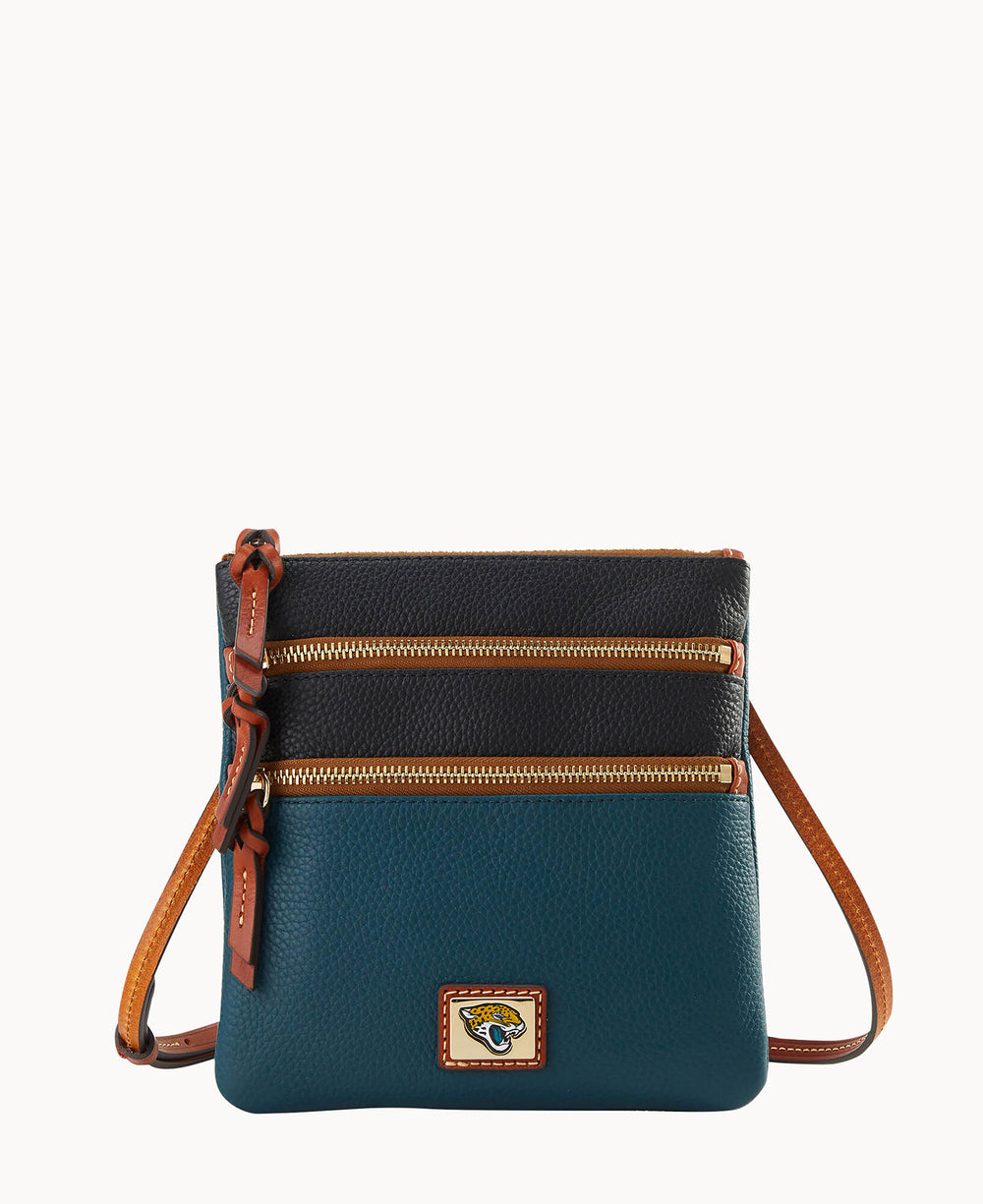 A small crossbody bag with a brown adjustable strap, two zippered compartments on the front, and color-blocked sections in dark teal and black pebbled leather, featuring a small logo patch at the bottom.