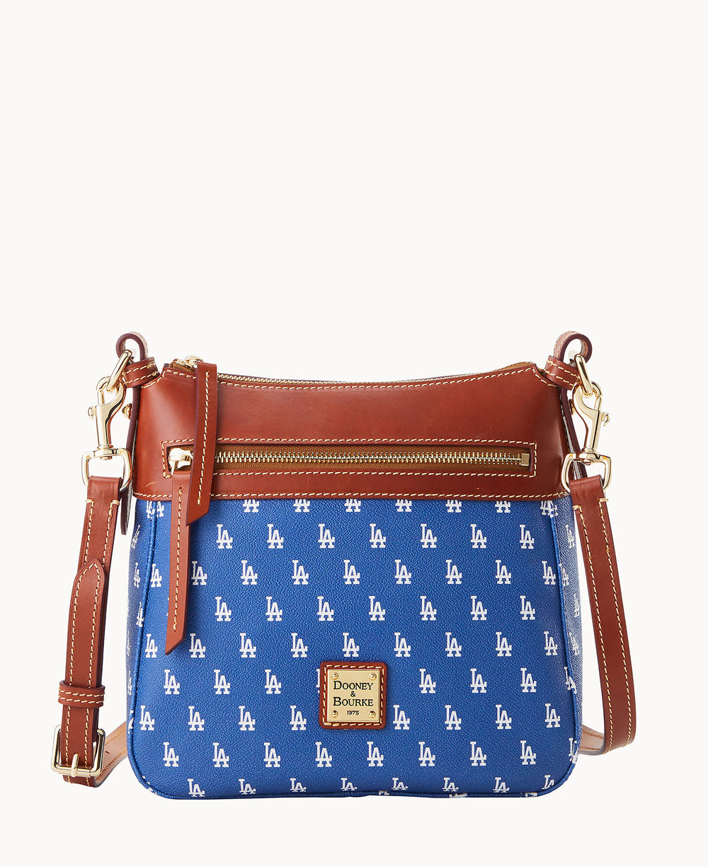 A blue crossbody bag with repeating white LA logos, brown leather trim, a front zipper pocket, gold hardware, and a Dooney & Bourke label on the front.