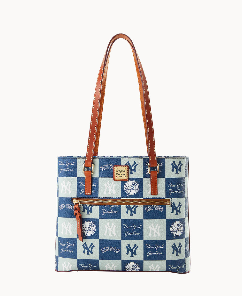 A tote bag featuring New York Yankees logos and text in blue and white, with two brown leather shoulder straps and a brown leather zipper pull.