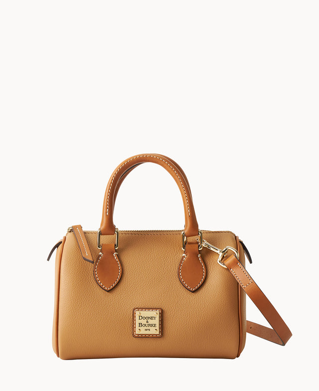 A tan leather handbag with two handles, a detachable shoulder strap, gold-tone hardware, and a metal Dooney & Bourke logo plate on the front, displayed against a white background.