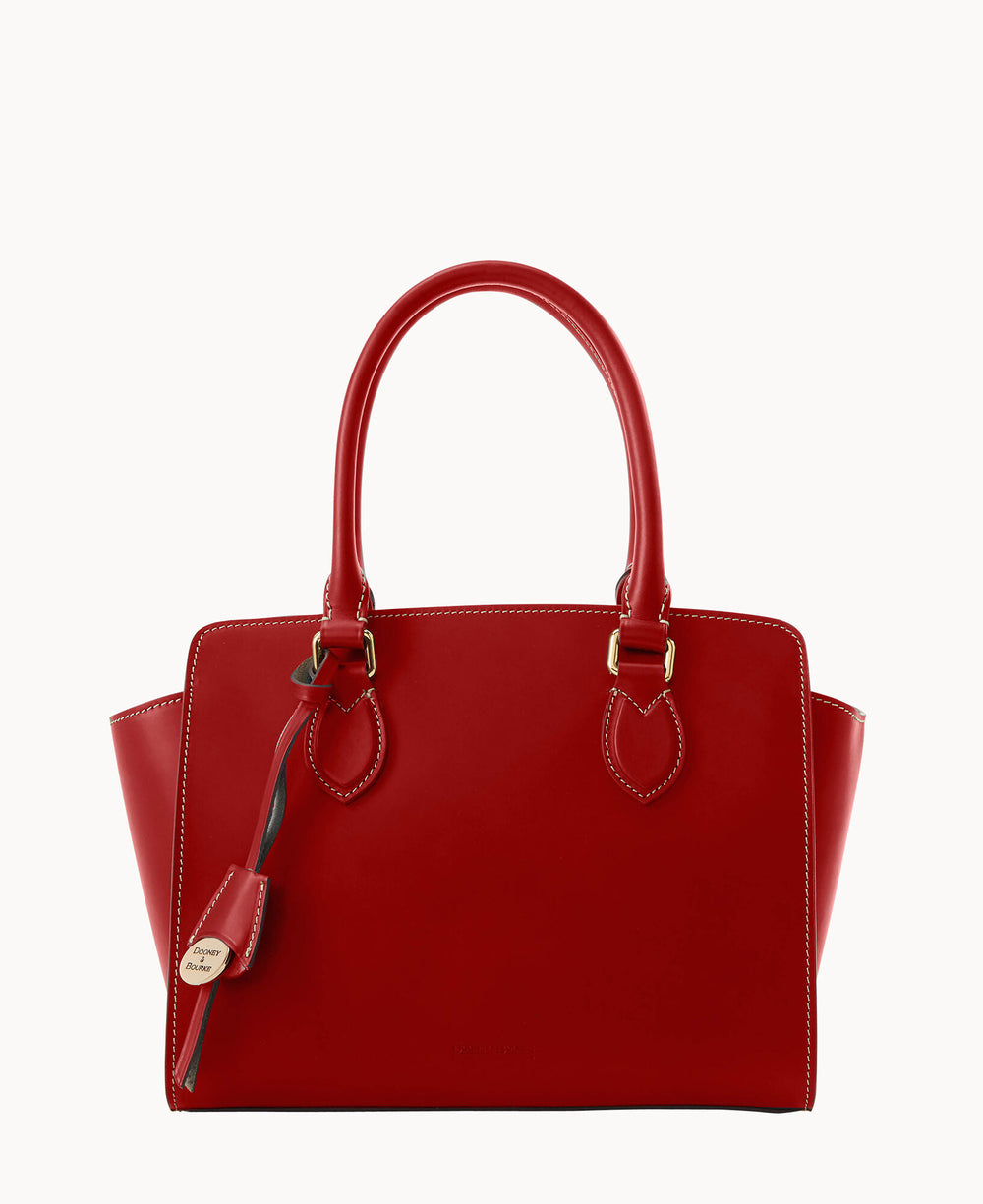 A red leather handbag with two handles, gold hardware, white stitching, and a decorative tag attached to one handle. The bag has a structured shape and a smooth finish.