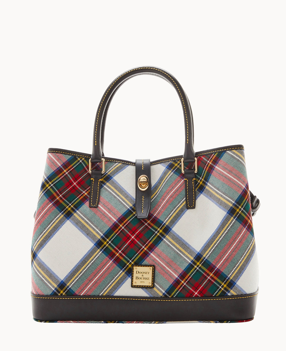 A structured handbag with dark leather handles and trim, featuring a colorful tartan plaid pattern in red, green, yellow, blue, and white. A gold clasp and a small gold label are on the front.