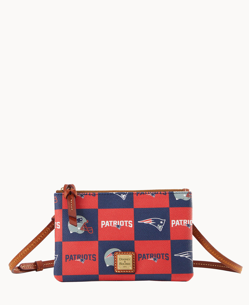 A small crossbody purse with a red and blue checkerboard pattern, featuring the New England Patriots logo, team name, and football helmet, with brown leather accents and a zipper closure.