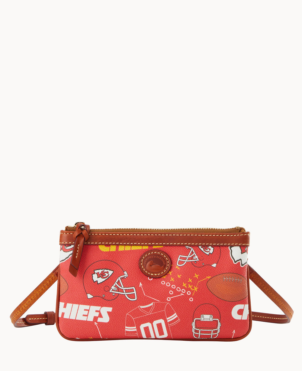 Small red crossbody bag with Kansas City Chiefs-themed graphics, including helmets, footballs, jerseys, and the teams logo, plus CHIEFS text. The bag has brown trim, a zipper closure, and a leather strap.