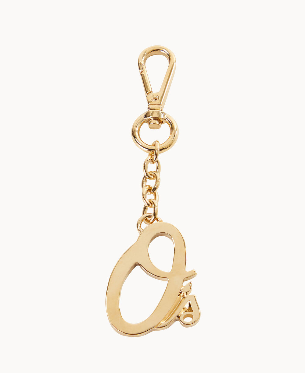 A gold keychain with a lobster clasp and a dangling pendant shaped like the lowercase letter a on a short chain.