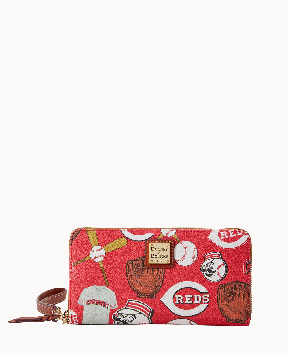 A red wallet featuring baseball-themed illustrations, including gloves, balls, jerseys, and Reds logos. It has a brown wrist strap and a gold Dooney & Bourke logo plate on the front.