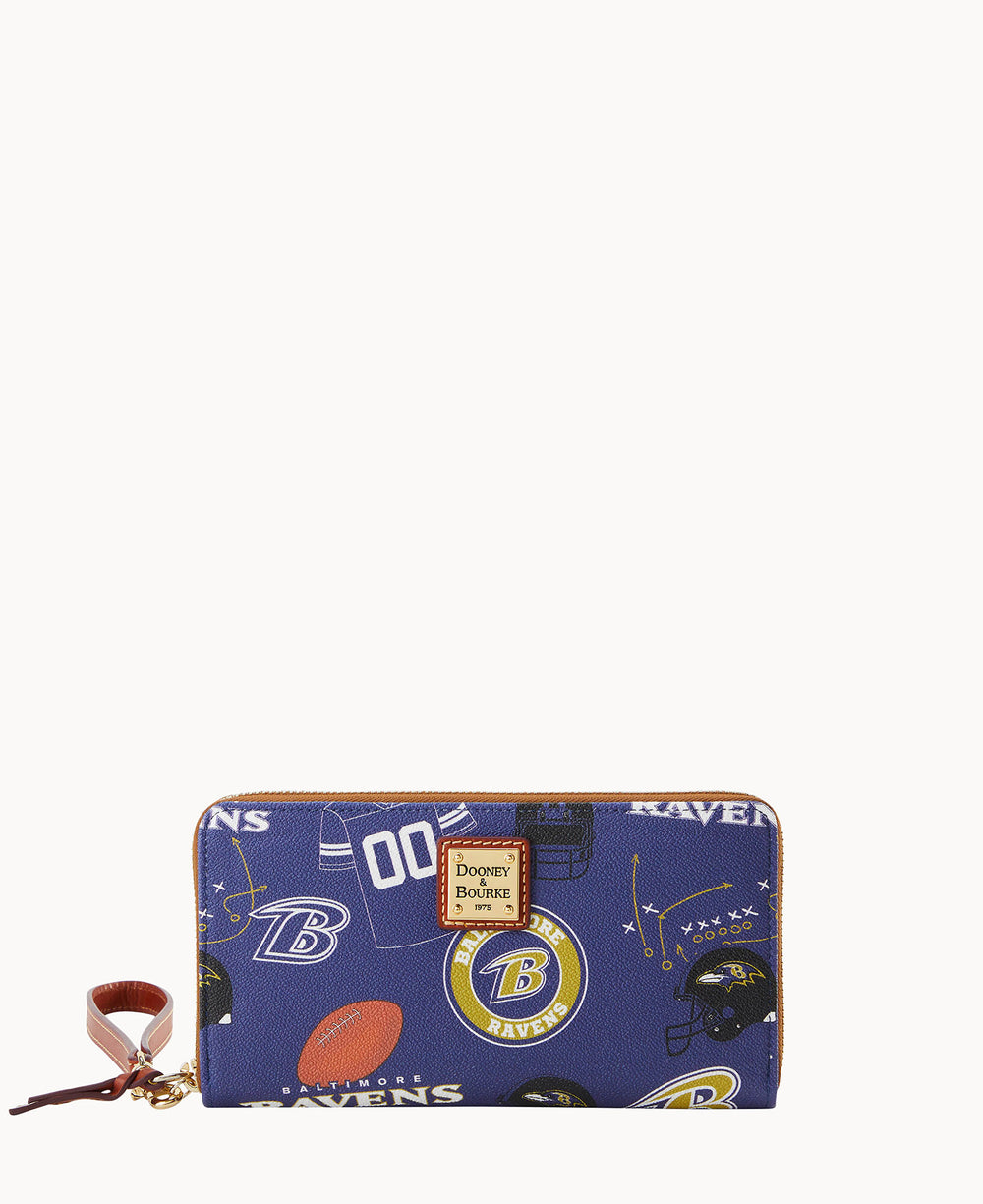A blue zippered wallet with Baltimore Ravens logos, football helmets, and jerseys, featuring a Dooney & Bourke label on the front and a brown leather wrist strap.