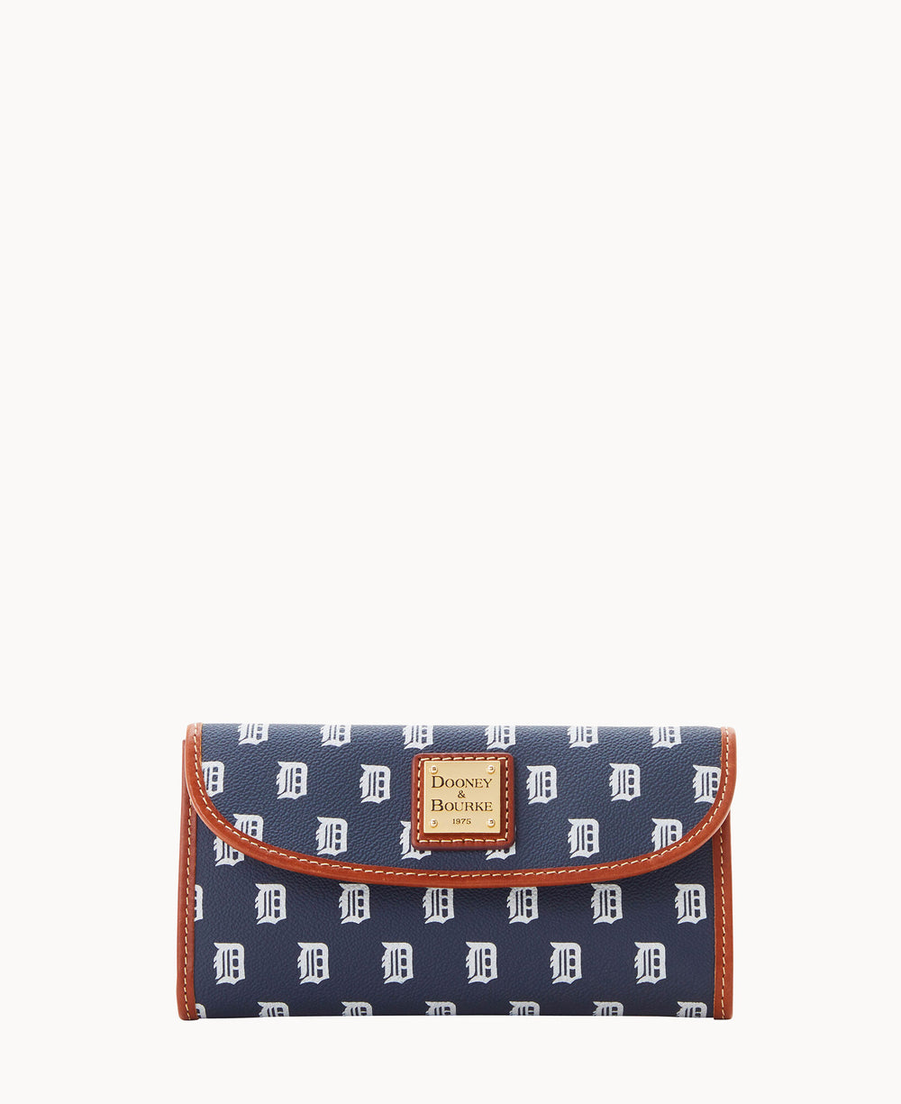 A navy blue Dooney & Bourke wallet with a repeating white D pattern, featuring brown trim and a gold logo plaque on the front.