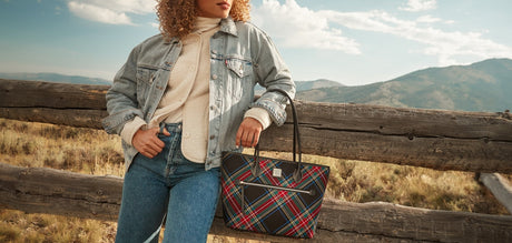 Woman standing in a field with a tartan Dooney & Bourke tote