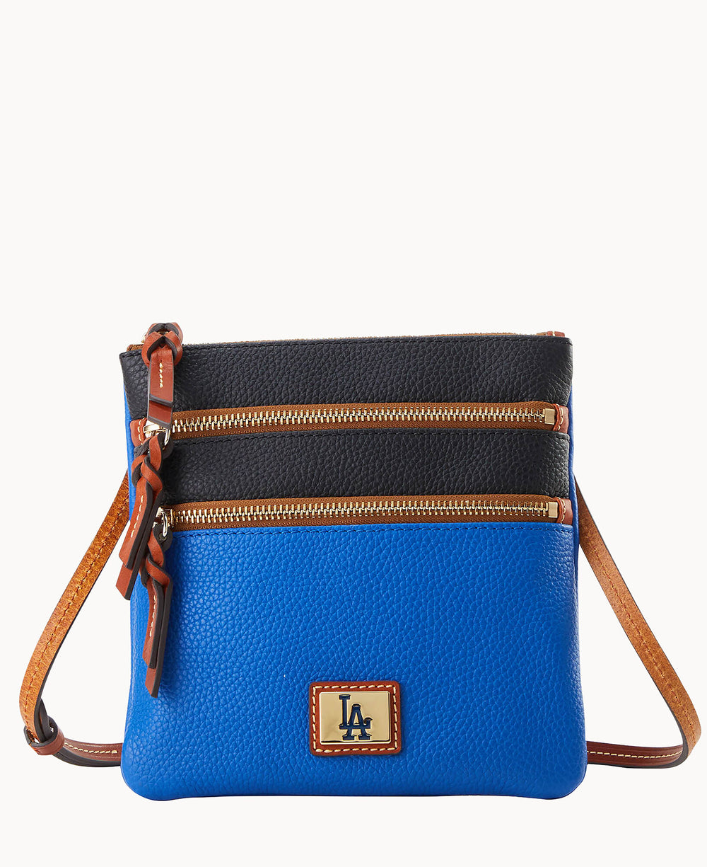 A crossbody bag with a blue lower half and black upper half, two zippered pockets, brown leather strap, and an LA logo patch on the front.