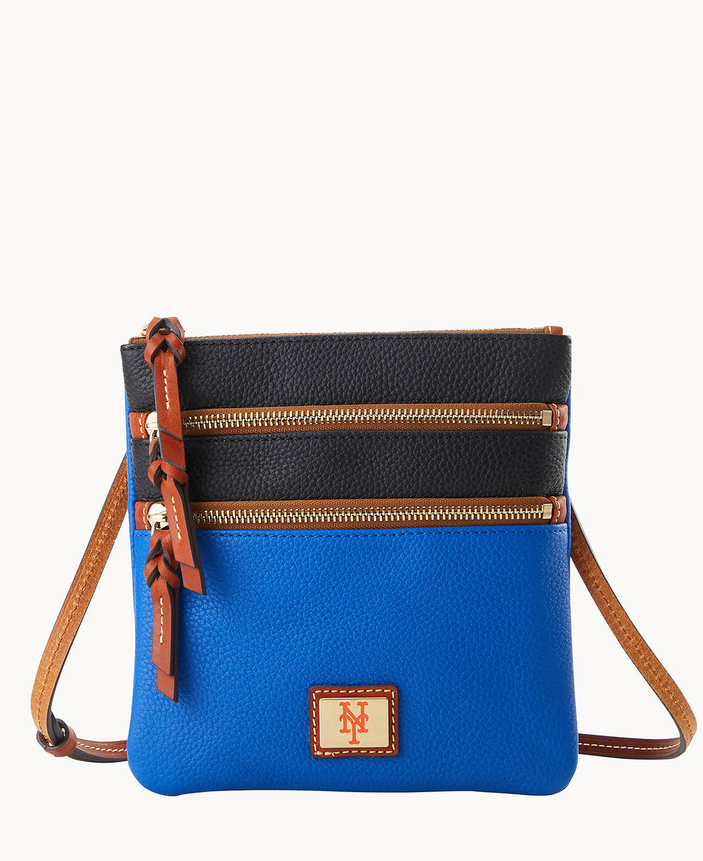 A small crossbody bag with blue leather on the lower half, black leather on the upper half, tan leather trim, two zippered pockets, and a New York Mets logo patch on the front.