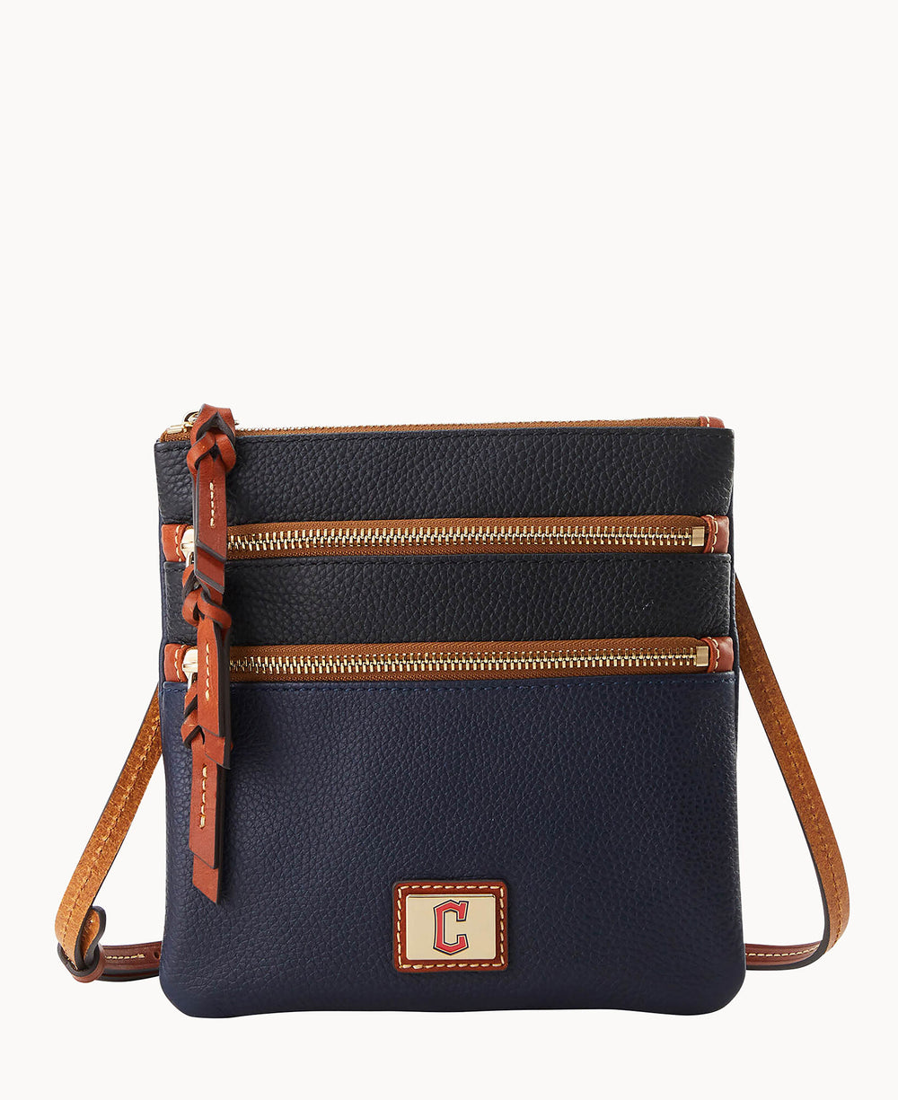 A navy blue and black leather crossbody bag with two front zippered pockets, brown leather accents, a matching adjustable strap, and a square logo patch featuring the letter C on the lower front.