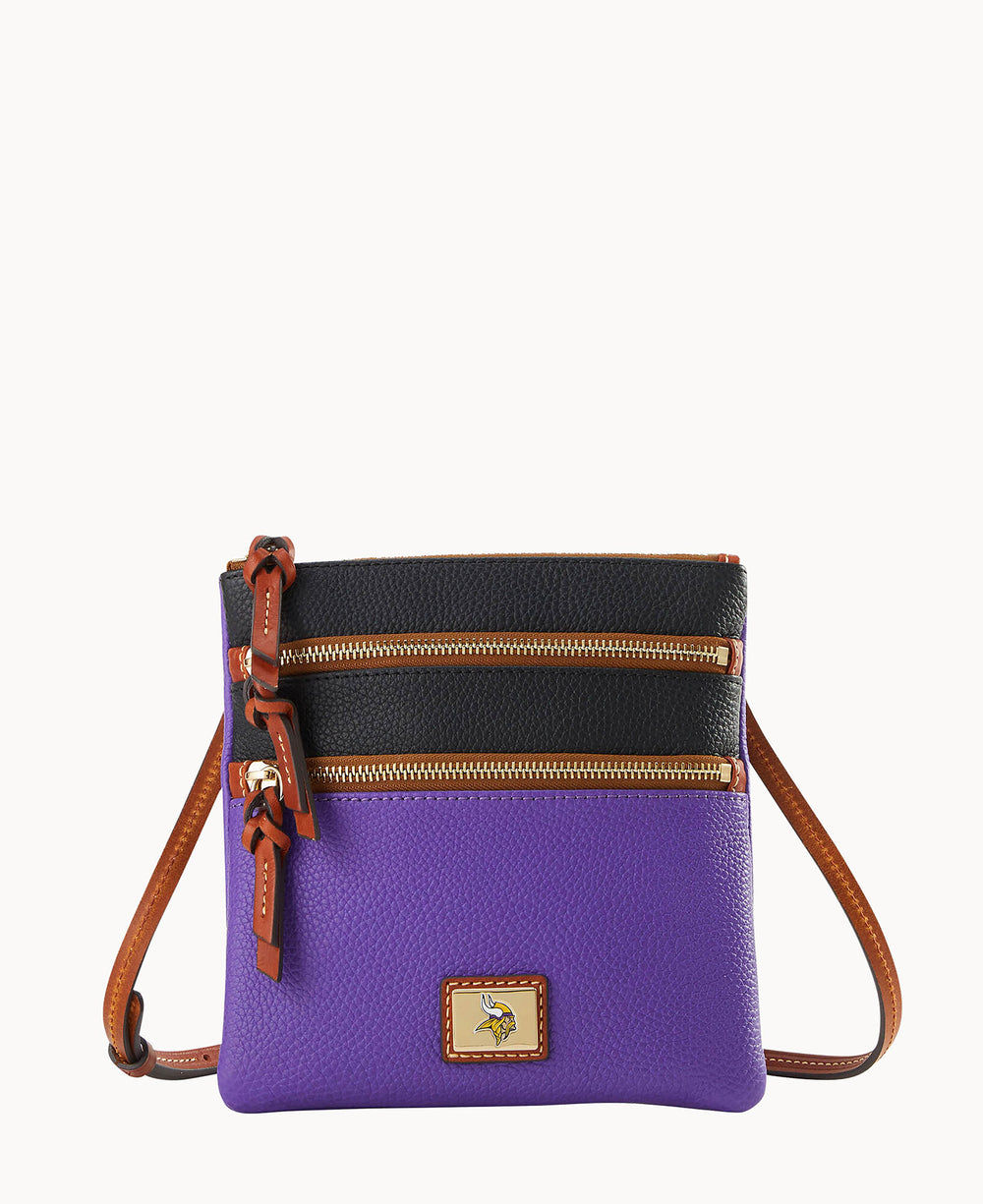 A small crossbody bag with a brown adjustable strap, featuring a purple lower half, black upper half, two gold zipper pockets, and a small logo patch at the bottom center.