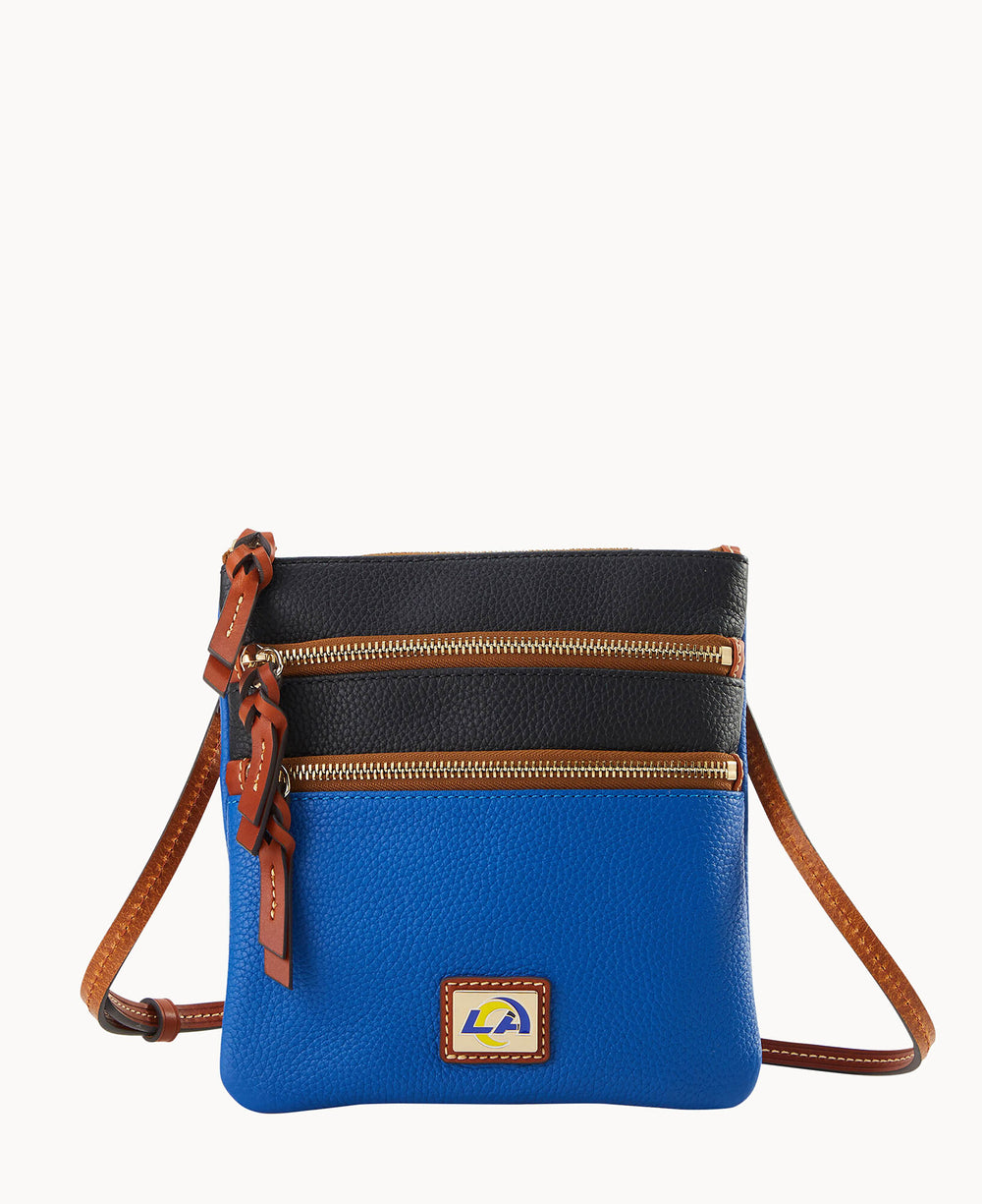 A small crossbody bag with a blue bottom half, black top half, two zippered pockets, brown strap and zipper pulls, and a patch with LA on the front.