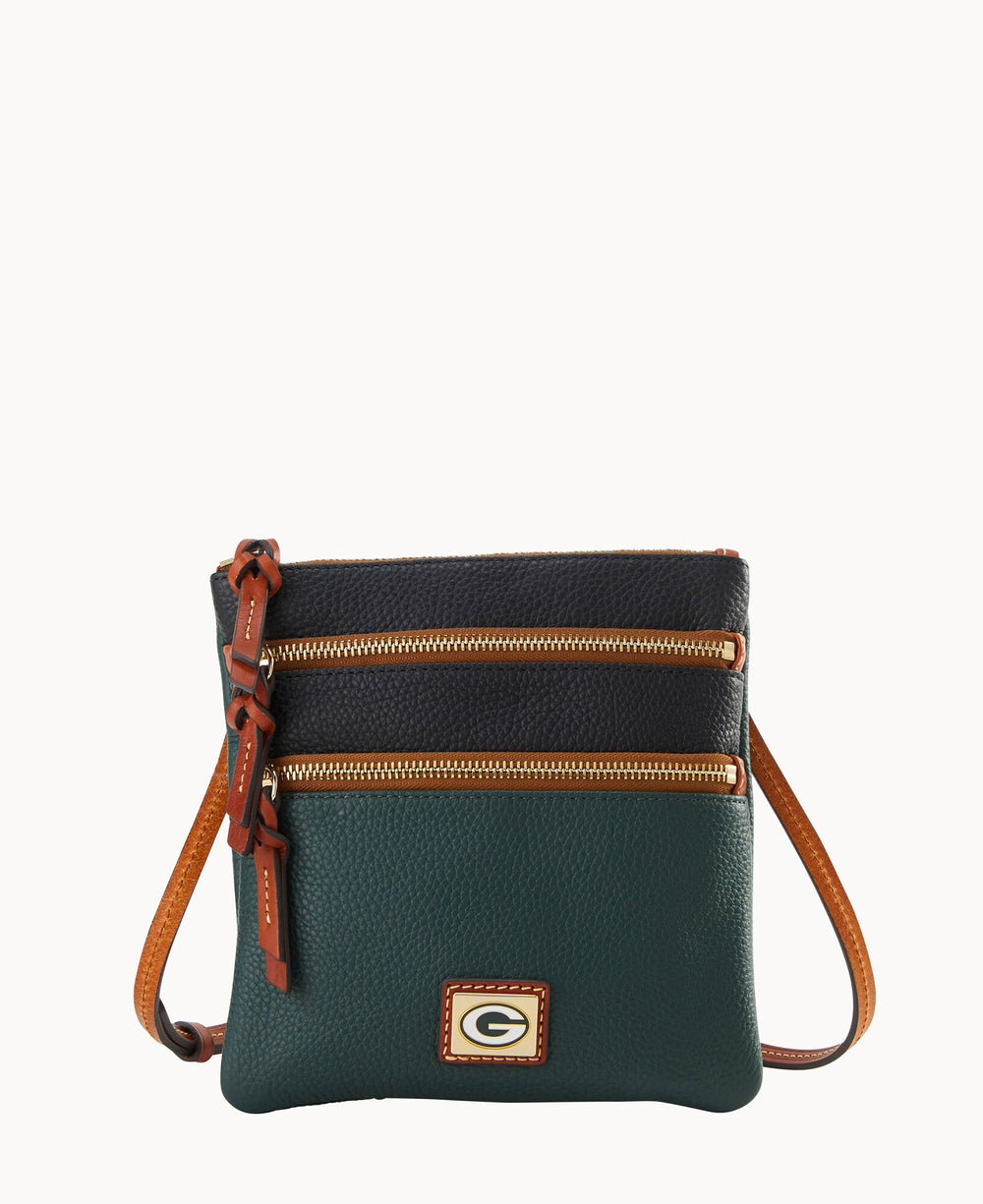 A small crossbody bag with a black and dark green pebbled leather finish, two gold zippers on the front, brown leather strap and accents, and a gold square logo on the lower front.
