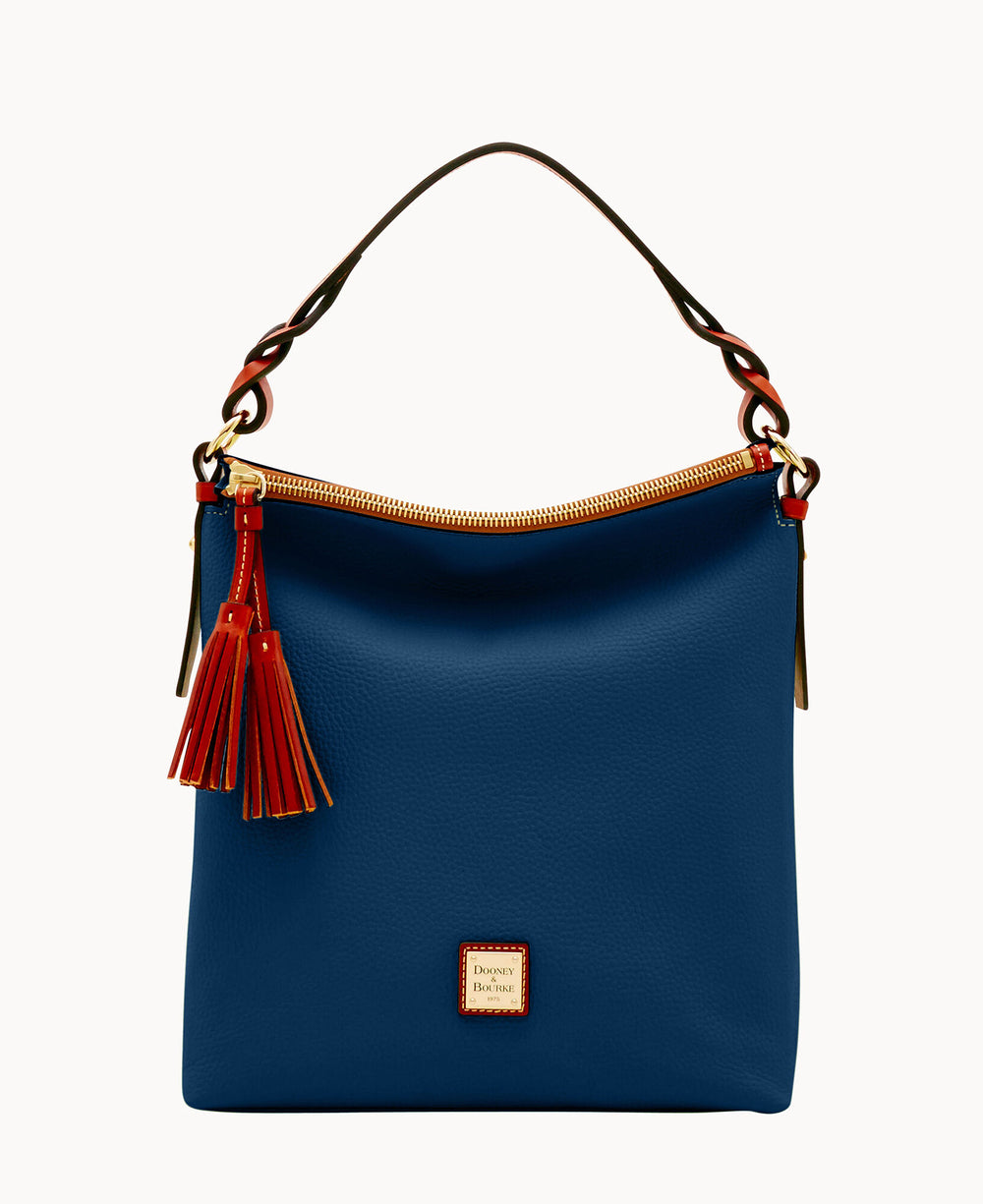A blue leather handbag with a curved handle, gold-tone hardware, red and orange tassel accents, and a small square logo patch on the front. The zipper and handle details are highlighted in contrasting colors.