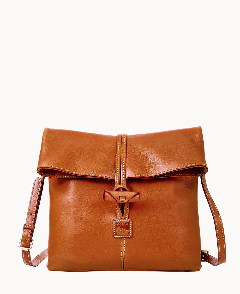 A brown leather crossbody bag with a fold-over flap, buckle closure, and adjustable strap. The bag has visible stitching and a minimalist, elegant design.