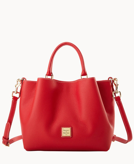 A bright red leather handbag with a textured finish, two short handles, a detachable shoulder strap, and a gold Dooney & Bourke logo plate on the front. The bag is displayed against a white background.