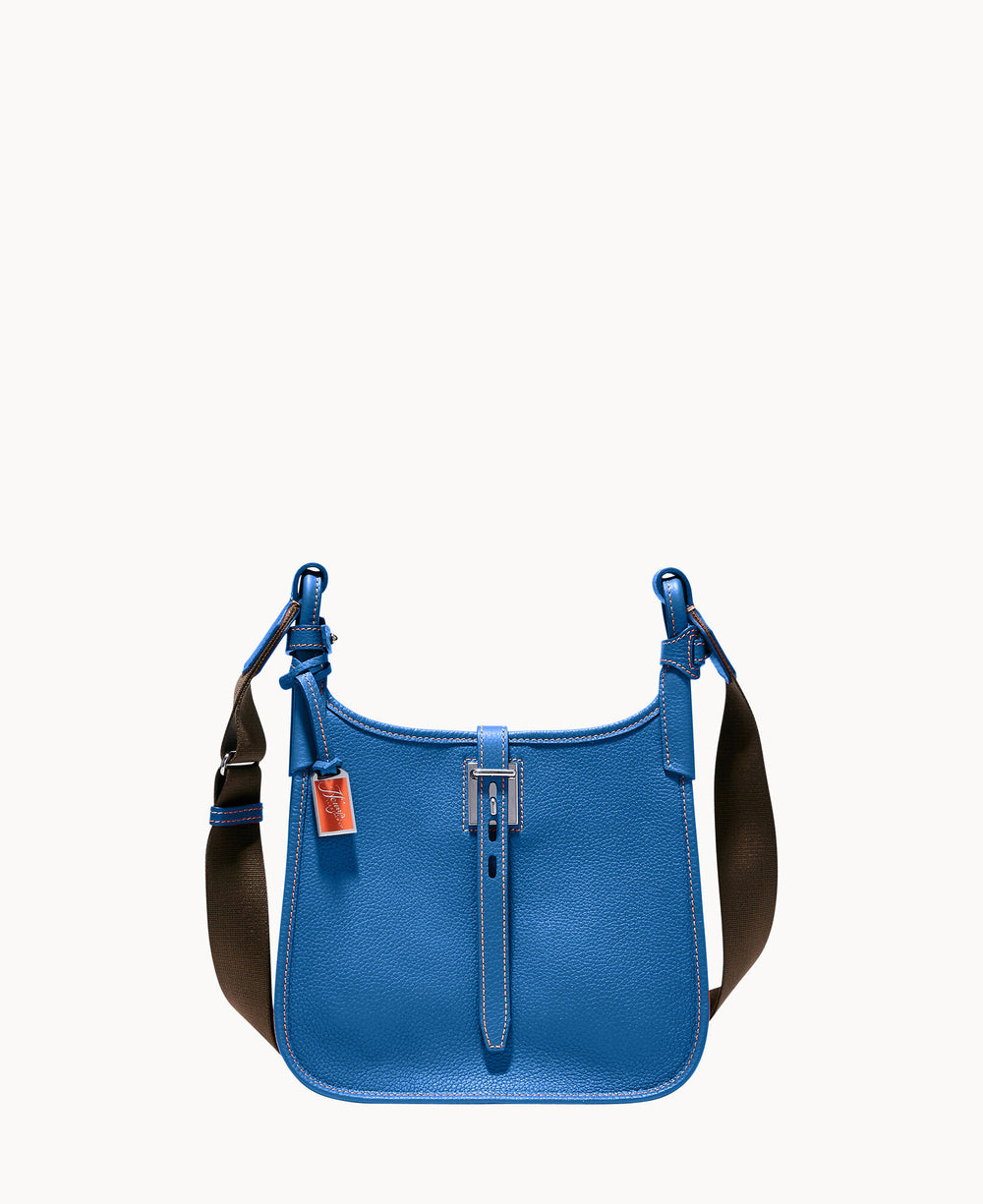 A blue leather shoulder bag with a wide dark strap, silver buckle, and a small red leather tag attached to one of the strap rings, set against a plain white background.