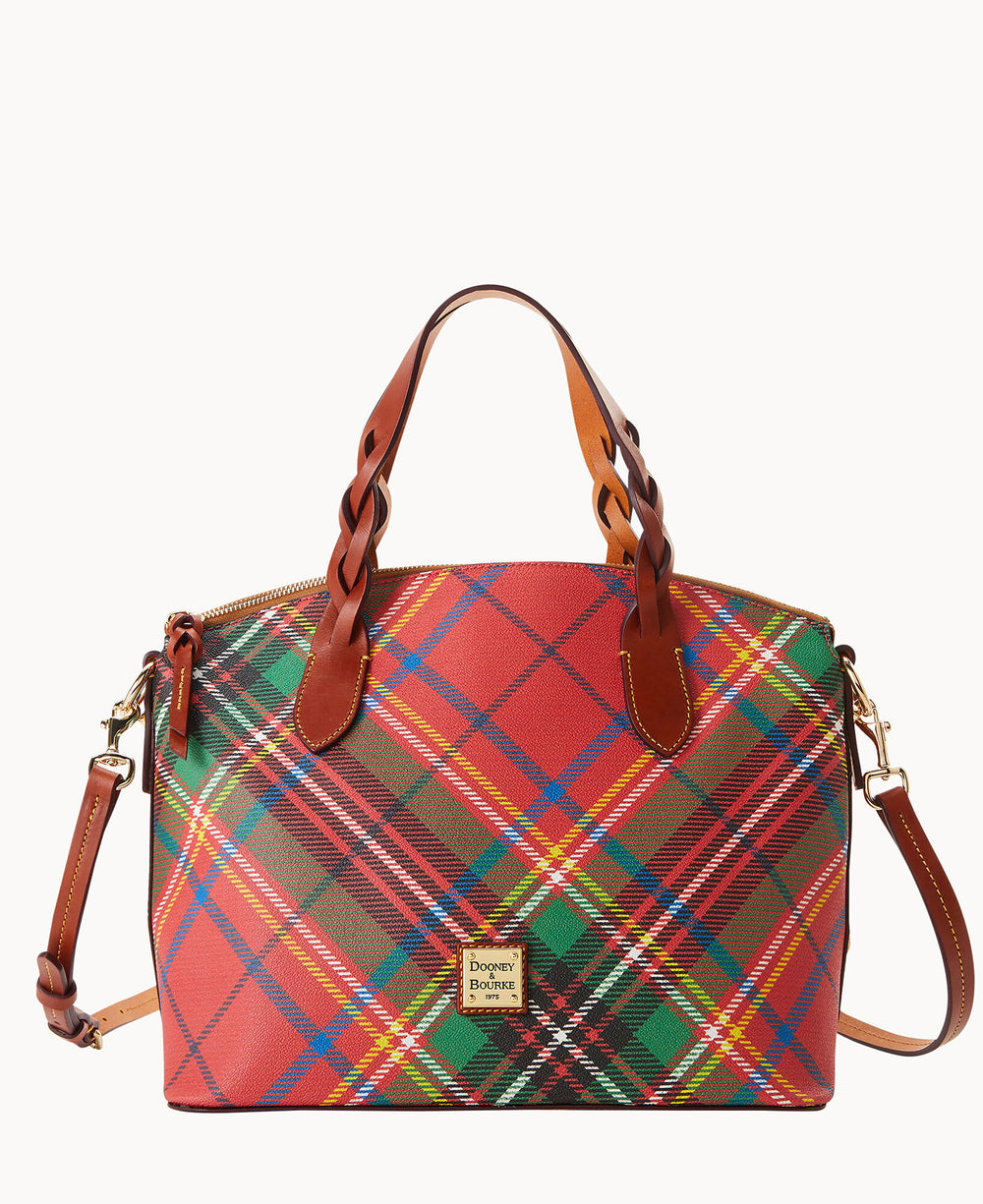 A plaid-patterned handbag with red, green, and yellow tones, tan leather handles, a detachable shoulder strap, and a gold Dooney & Bourke logo plate on the front.