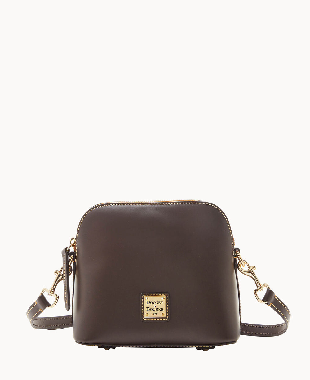 A small, dark brown leather crossbody bag with gold hardware, adjustable strap, and a square Dooney & Bourke logo plaque on the front, photographed against a plain white background.