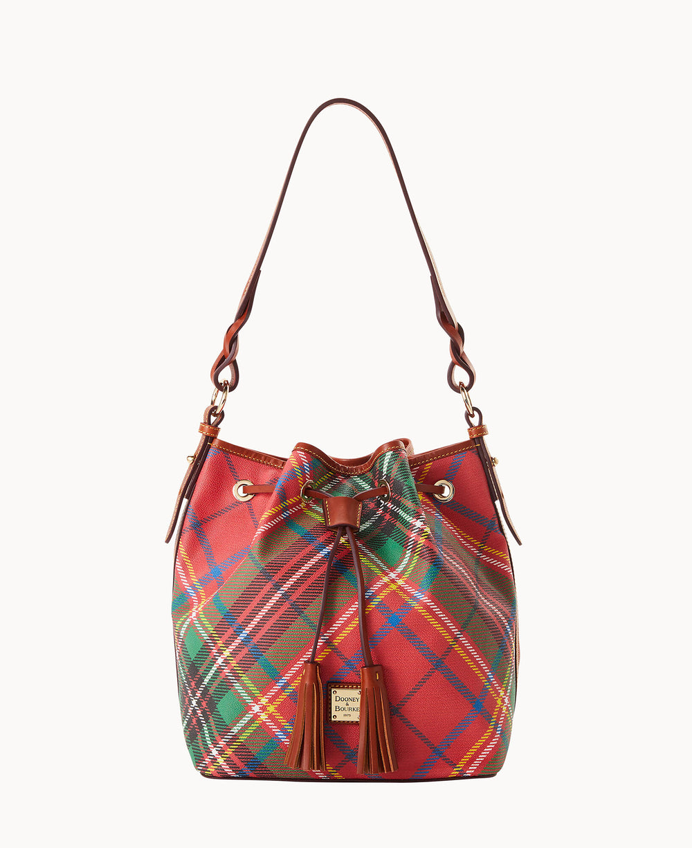 A bucket-style handbag with a red, green, and yellow plaid pattern, brown leather strap and accents, a tassel detail, and a small gold brand label on the front.