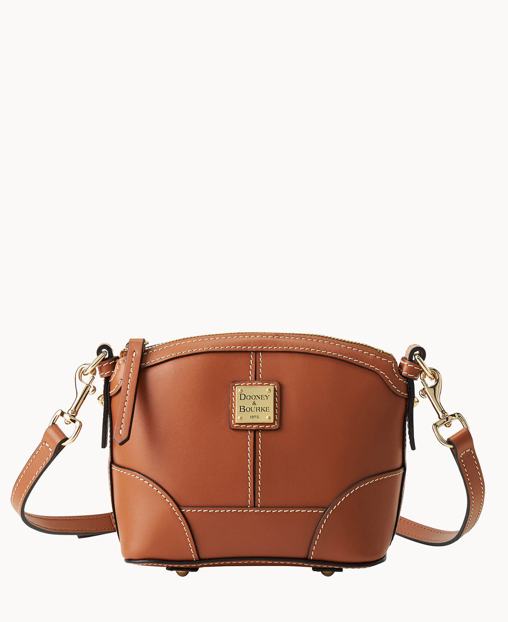 A small brown leather crossbody bag with white stitching, gold hardware, and a rectangular Dooney & Bourke logo plaque on the front. The bag has an adjustable strap and a simple, structured design.