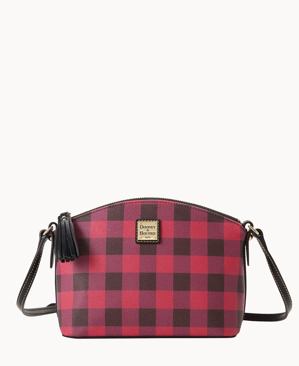 A red and black checkered crossbody bag with a zip closure, black strap, tassel detail, and a gold Dooney & Bourke logo plate on the front.