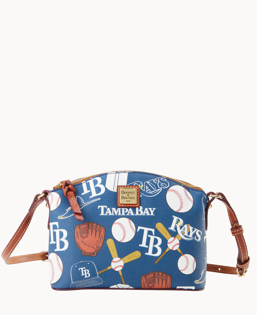 A blue crossbody purse with brown straps featuring Tampa Bay Rays logos, baseballs, bats, gloves, and Tampa Bay text in a repeating pattern. The bag has a gold zipper and a square logo patch on the front.