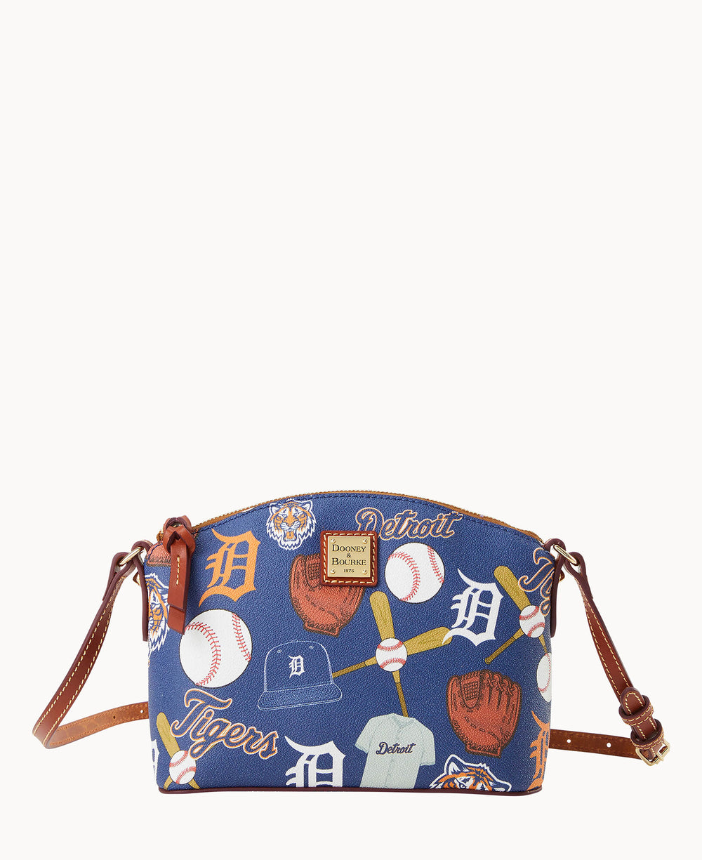 A blue crossbody bag with brown leather straps, decorated with Detroit Tigers baseball-themed graphics including gloves, bats, caps, and the teams logo.