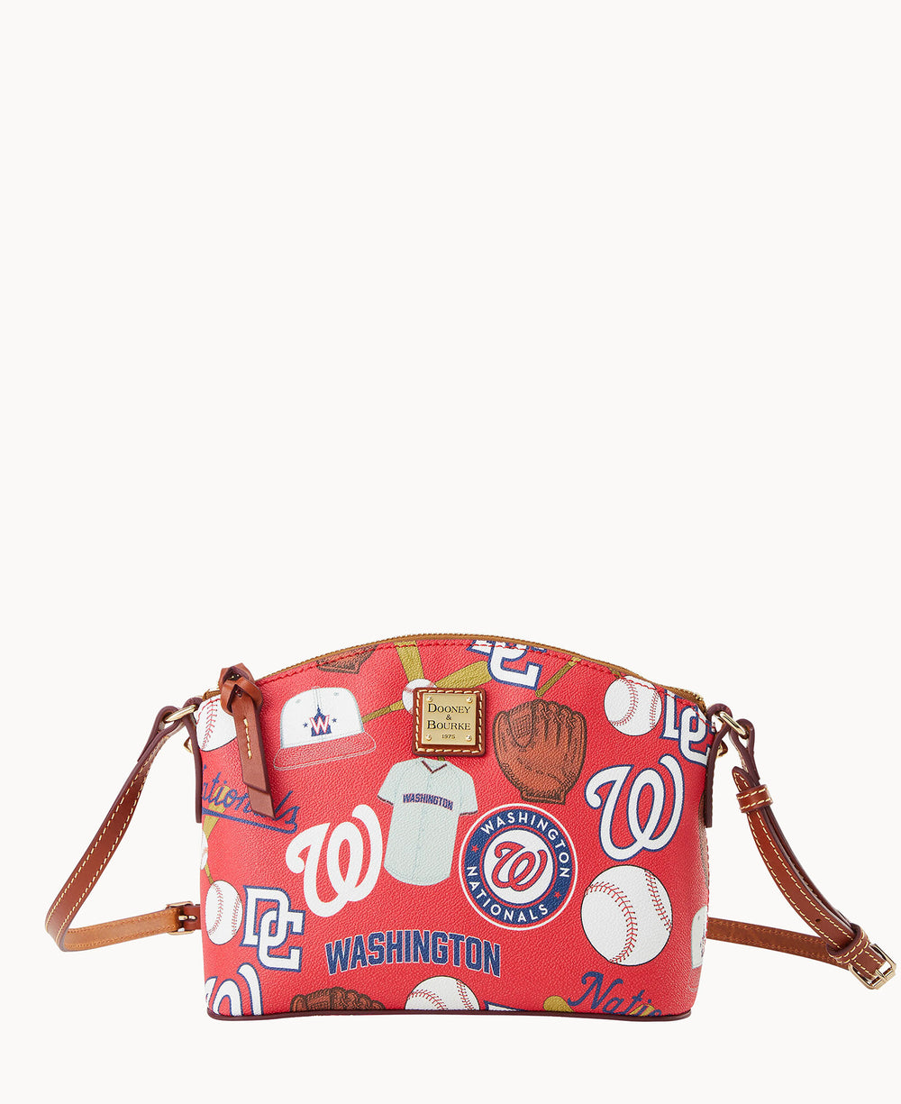 A red crossbody bag with brown leather straps featuring Washington Nationals baseball-themed graphics, including team logos, baseballs, bats, and the word Washington.