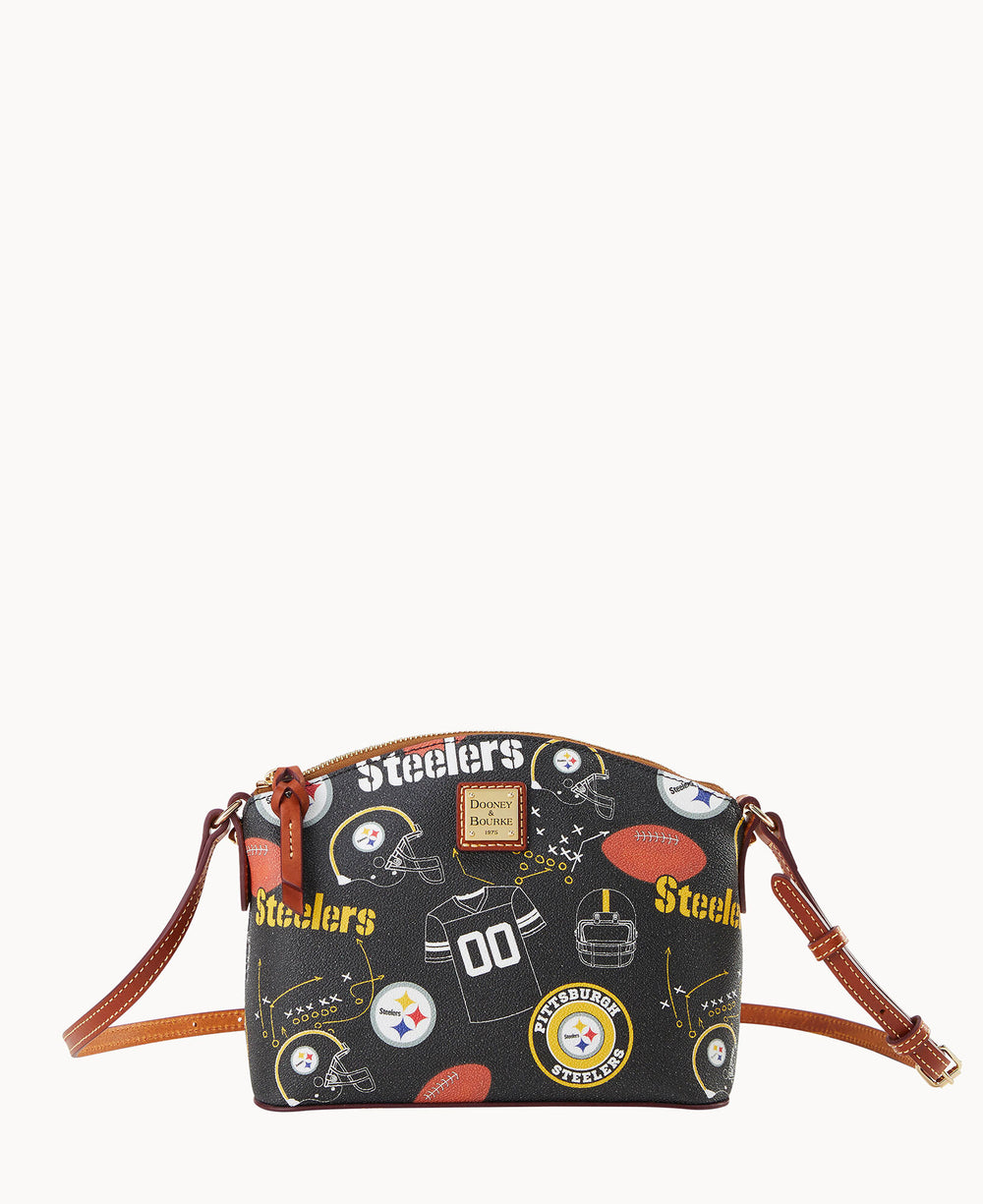 A black crossbody bag with brown straps, decorated with Pittsburgh Steelers logos, footballs, helmets, and the word â€œSteelersâ€ in yellow and white. The bag has gold-tone hardware and a small front label.