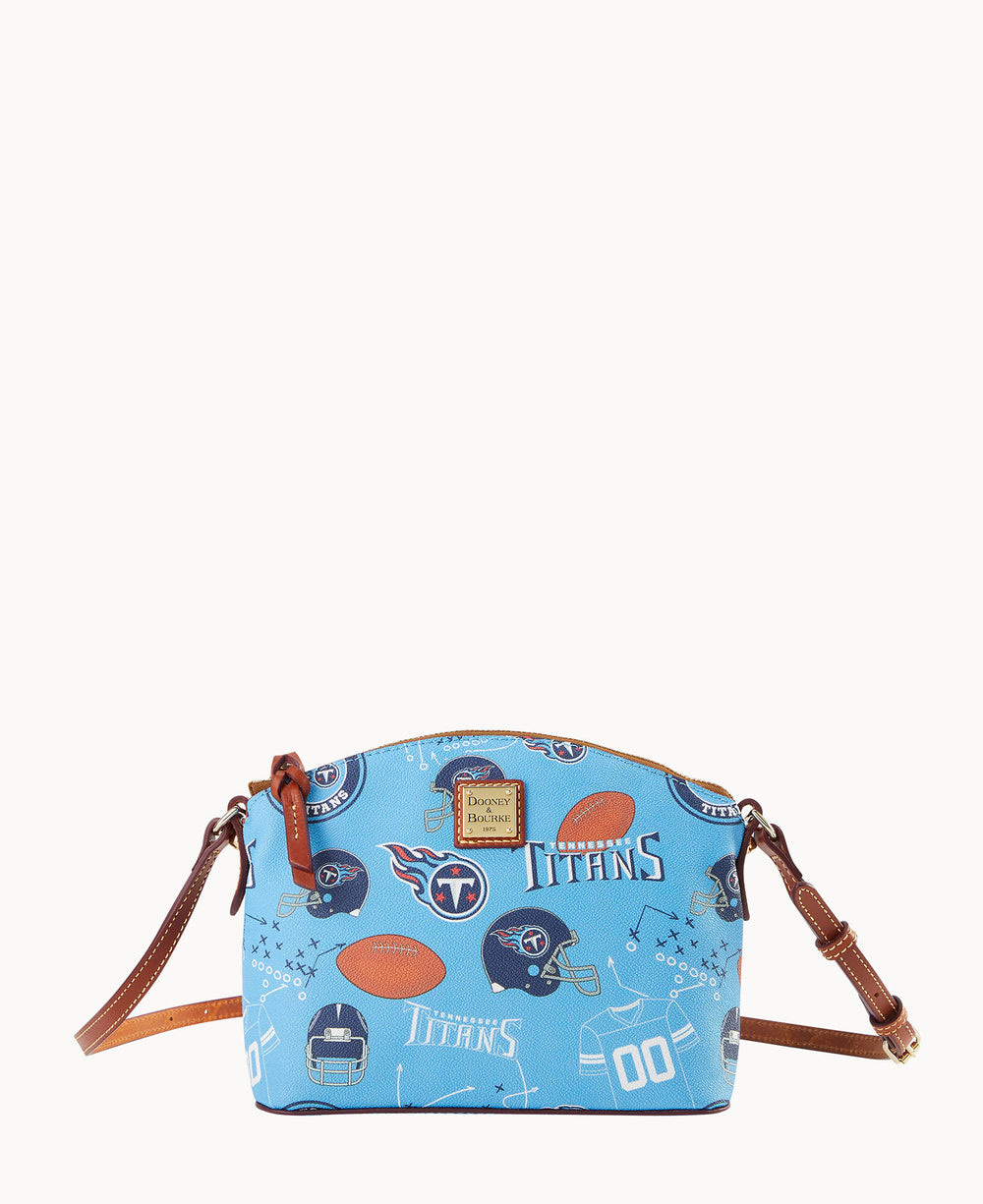 Light blue crossbody bag with brown leather straps, featuring Tennessee Titans football-themed graphics including helmets, footballs, and the Titans logo.