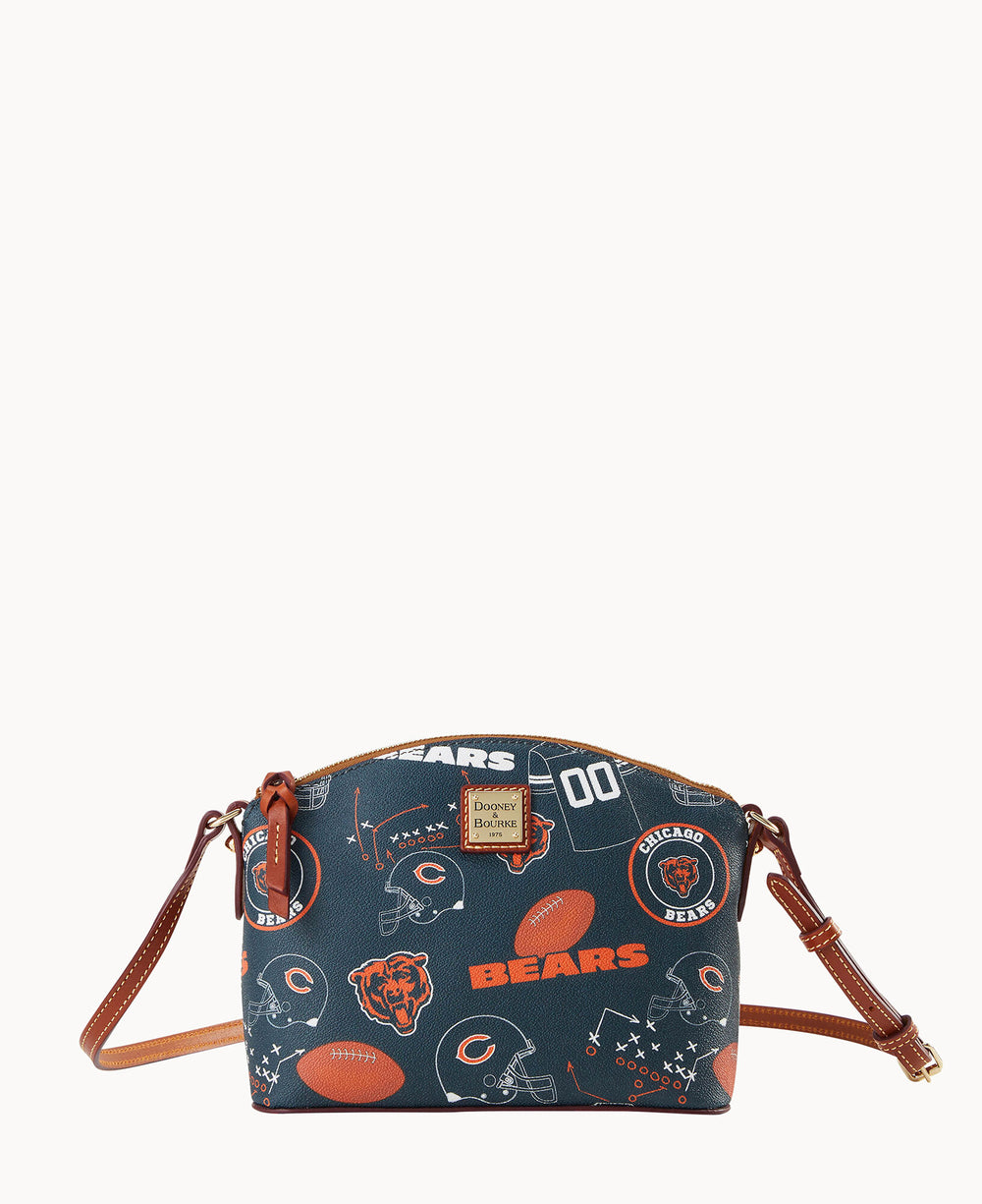 A navy blue crossbody bag with brown leather accents, featuring Chicago Bears logos, footballs, helmets, and play diagrams in a scattered pattern.