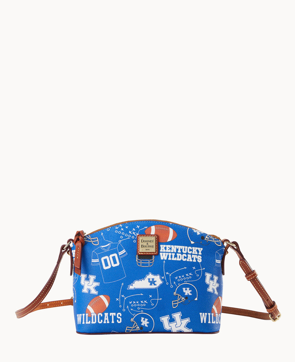 A blue crossbody bag with brown leather straps, featuring University of Kentucky Wildcats logos, footballs, and related graphics. The bag has a Dooney & Bourke logo patch on the front.