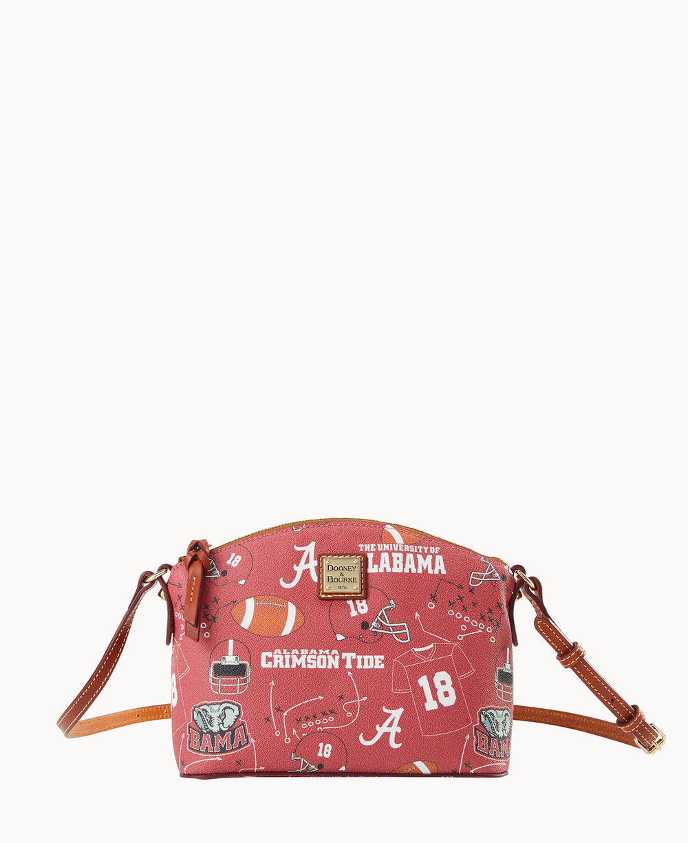 A small red crossbody bag with brown straps, featuring University of Alabama-themed prints, including footballs, helmets, jerseys, and â€œCrimson Tideâ€ text.