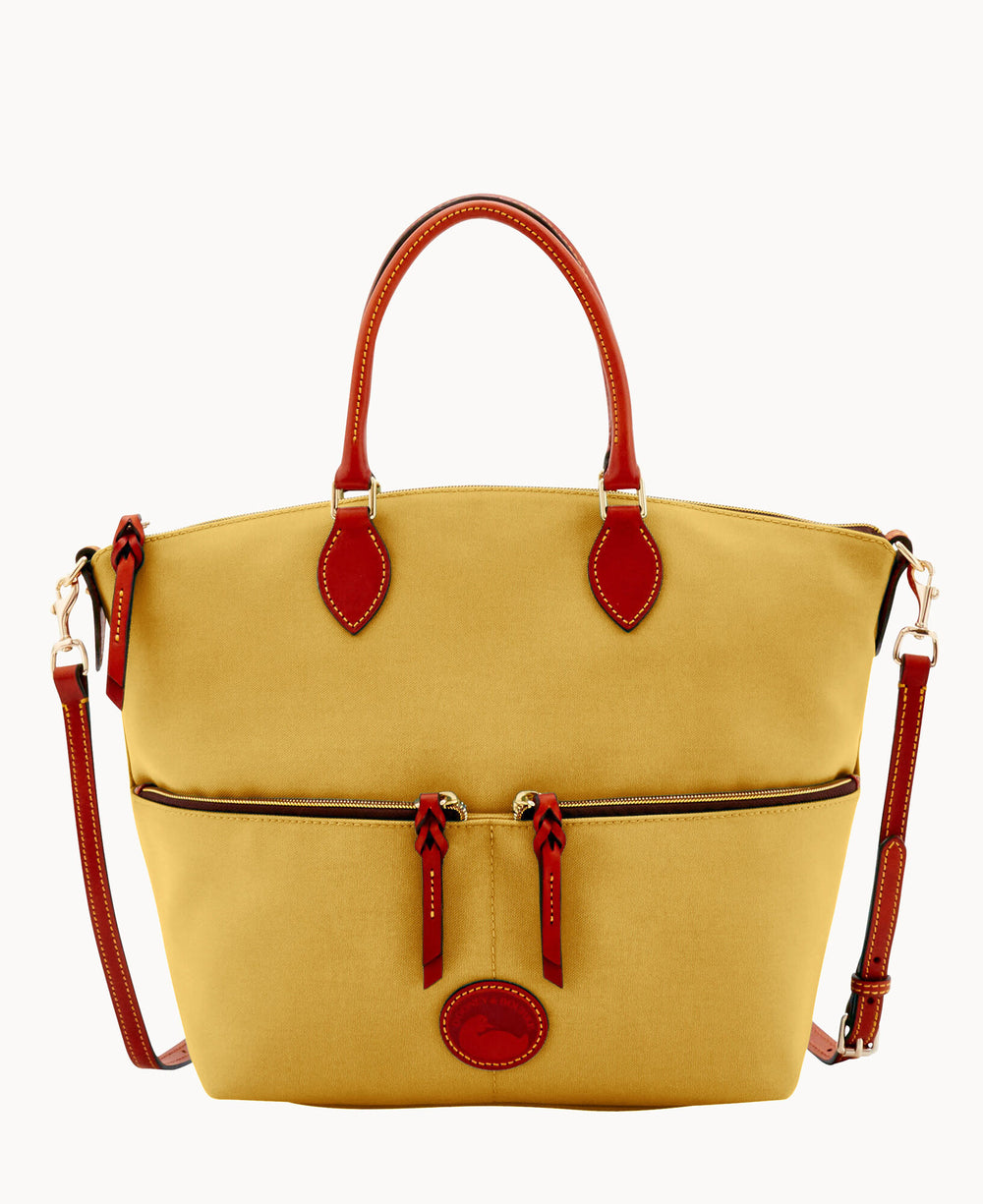 A tan canvas handbag with red leather handles and accents, featuring gold hardware, a zippered front pocket with two zipper pulls, and a detachable shoulder strap.