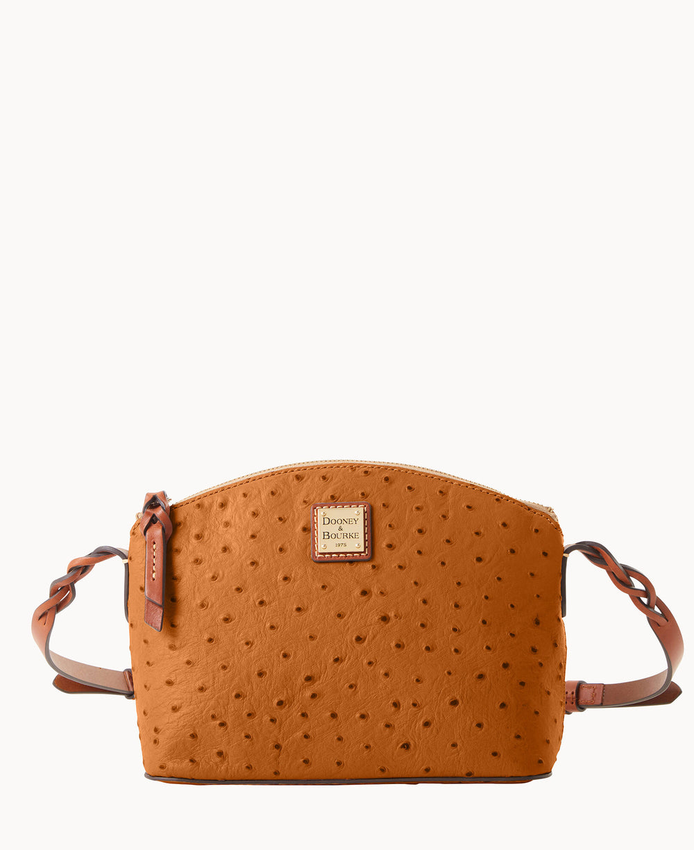 A brown, textured leather crossbody bag with a curved top, gold zipper, braided straps, and a small Dooney & Bourke logo patch on the front.