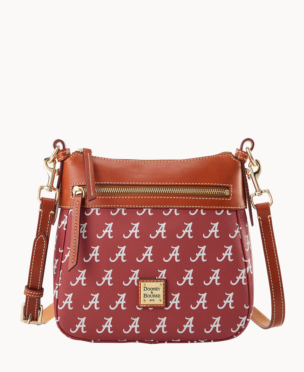 A maroon Dooney & Bourke crossbody bag with brown leather accents, gold hardware, and an all-over repeating white A pattern. The front features a zipper pocket and a logo plaque.