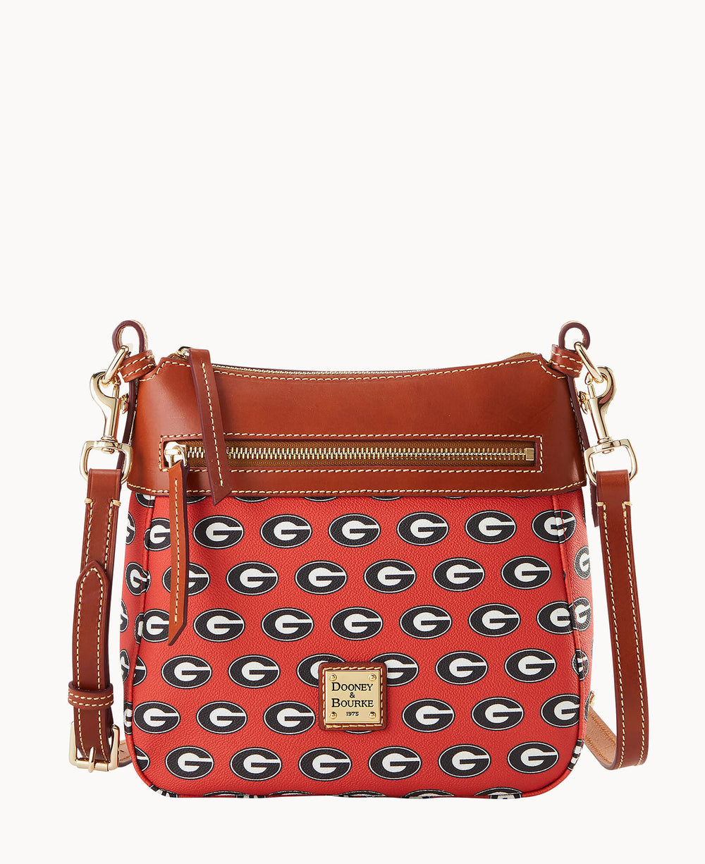 A red and brown Dooney & Bourke crossbody bag featuring a repeating black and white G logo pattern, gold-tone hardware, a front zipper pocket, and a leather strap.
