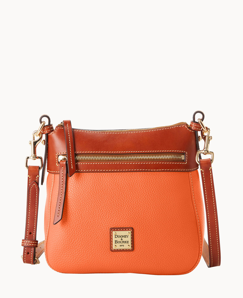 An orange and brown leather crossbody bag with a front zipper pocket, gold hardware, adjustable strap, and a small Dooney & Bourke logo plaque on the front.