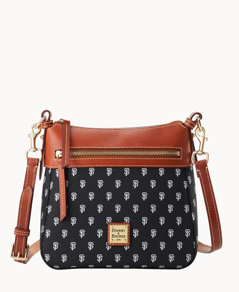 A black crossbody bag with brown leather trim, gold hardware, a front zipper pocket, and an adjustable strap. The bag features a repeating white SF pattern and a Dooney & Bourke logo plate on the front.