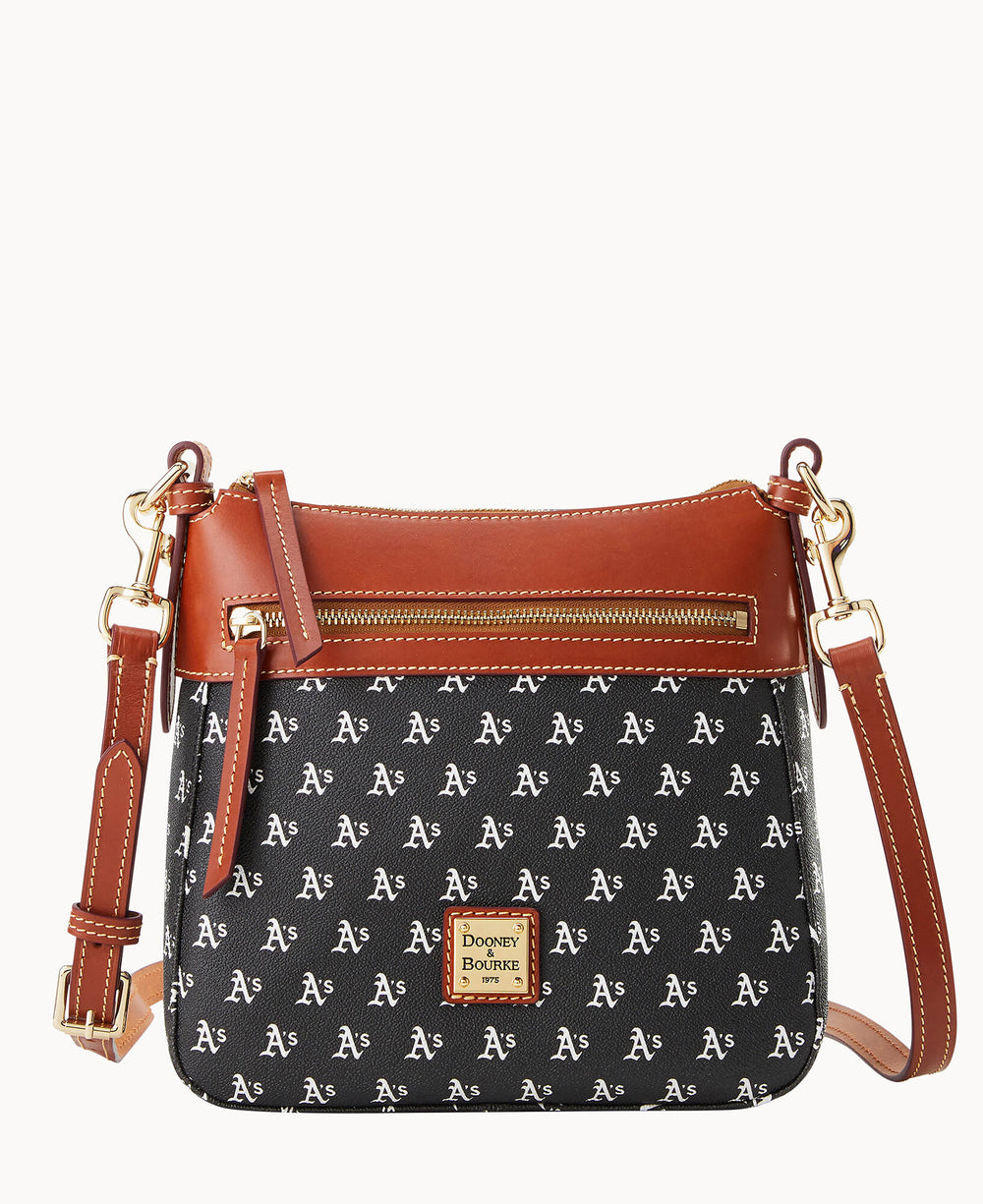 A small black crossbody bag with brown leather trim and strap, gold hardware, and a repeating white â€œAâ€™sâ€ pattern. The front features a Dooney & Bourke logo patch.
