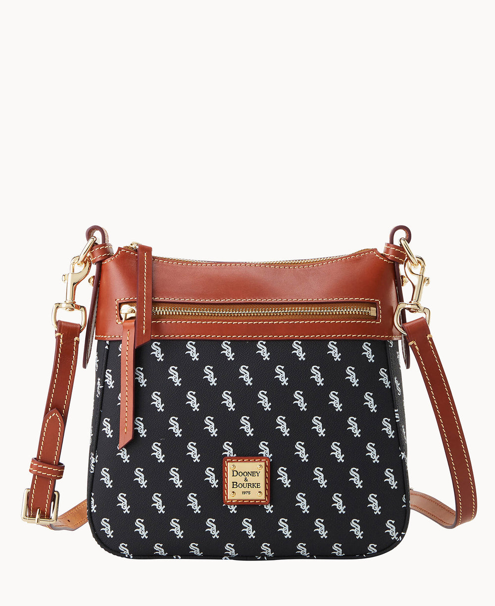 A black crossbody purse with a brown leather strap, brown leather trim, gold hardware, and a front zipper. The bag features a repeating white Sox logo pattern and a gold Dooney & Bourke label on the front.