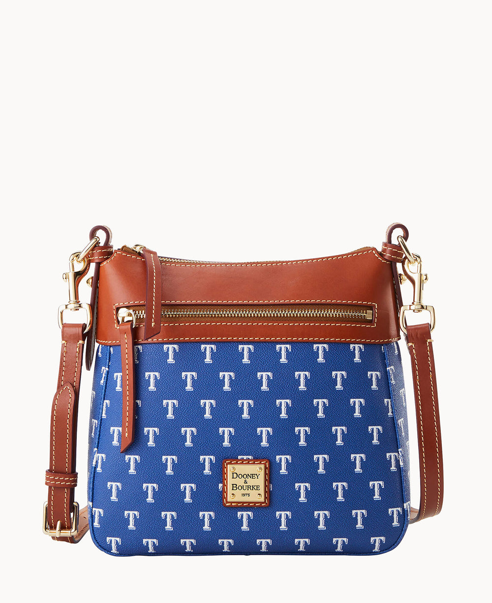 A blue crossbody bag with repeating white T logos, brown leather trim, a front zipper pocket, and a gold Dooney & Bourke logo plate. The bag has an adjustable brown leather strap.