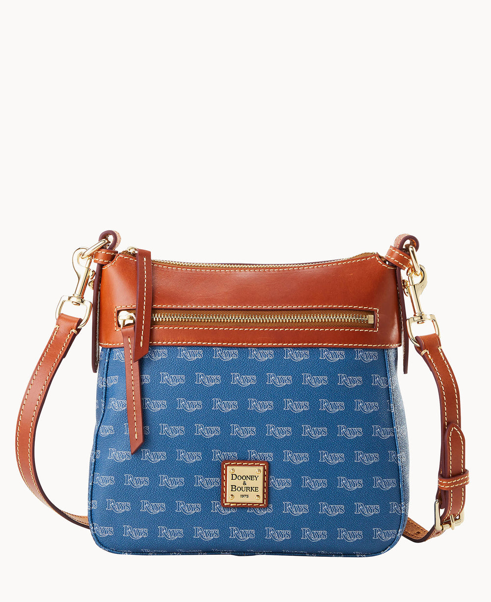 A blue Dooney & Bourke crossbody bag with a brown leather trim, gold zipper, and adjustable strap. The blue area is patterned with the word Rays in white text. The logo patch is on the front bottom center.