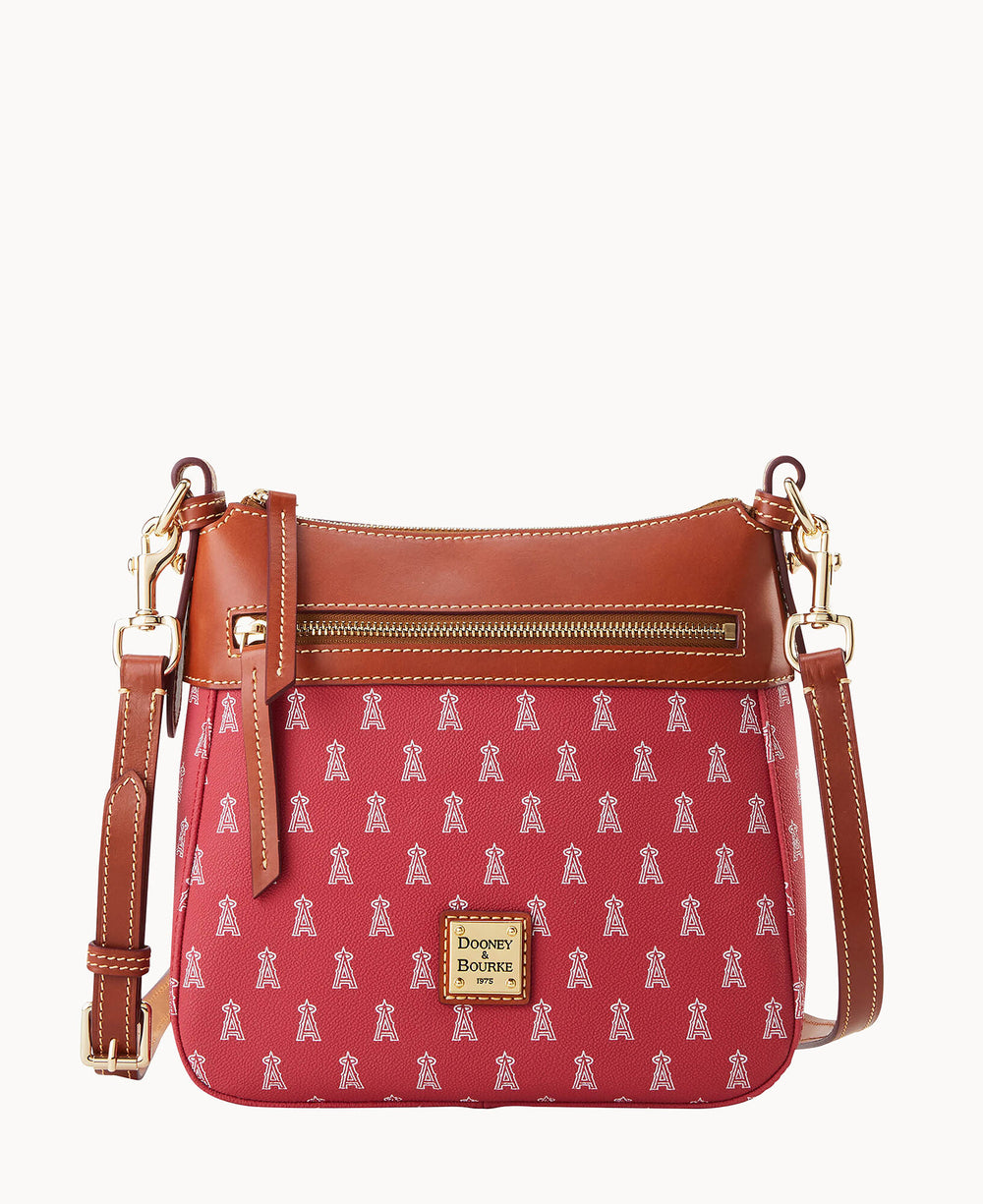 A red crossbody bag with brown leather trim, gold hardware, a front zip pocket, and a repeating white â€œAâ€ pattern. The center features a gold Dooney & Bourke logo plate.