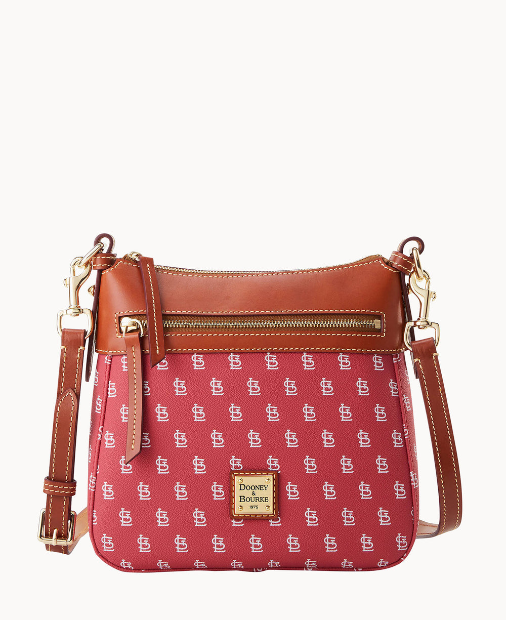 A red Dooney & Bourke crossbody bag with a brown leather trim, gold accents, a front zipper pocket, and a repeating white DB logo pattern. The bag has an adjustable strap and a logo patch on the front.