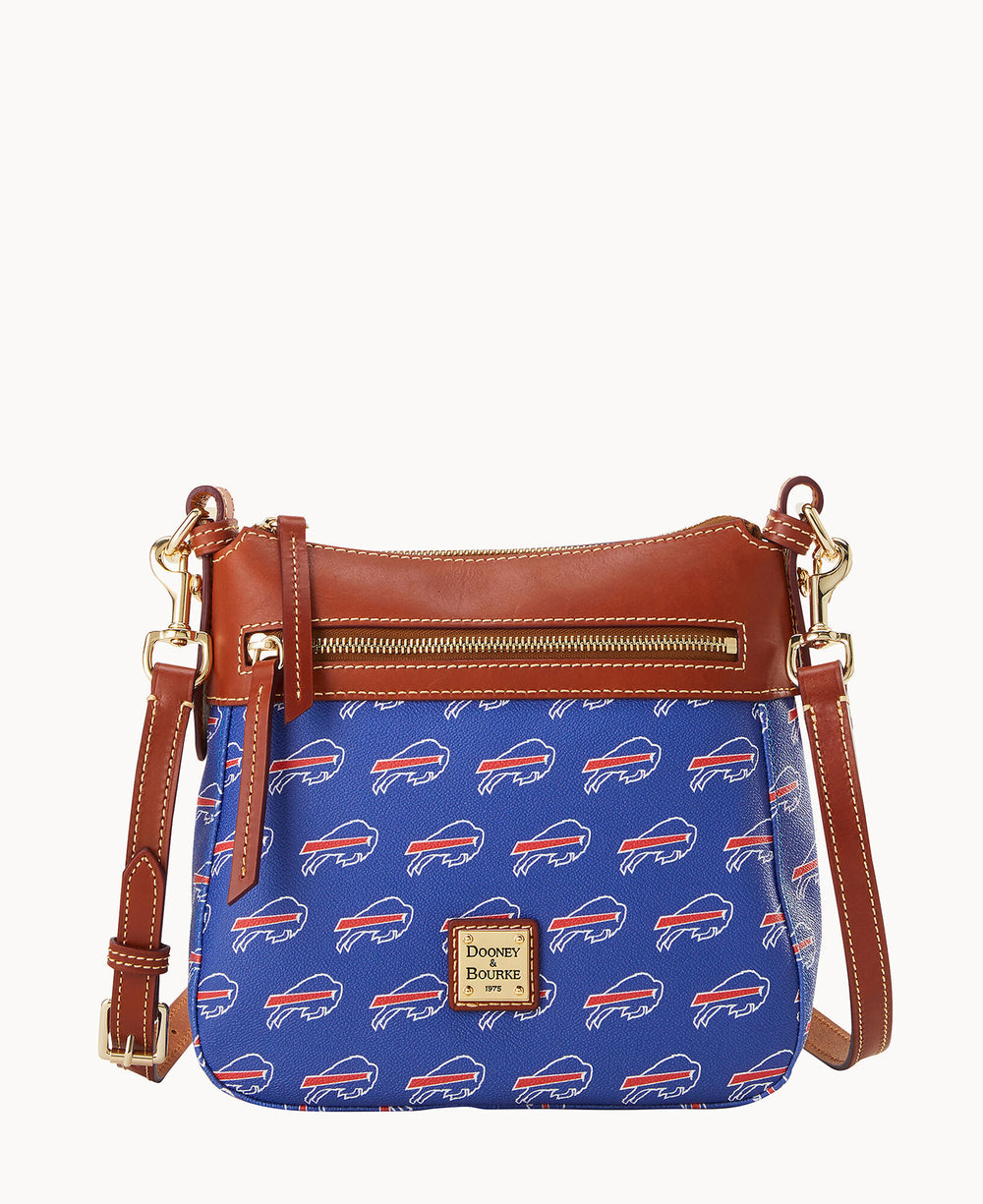 A blue Dooney & Bourke crossbody bag with a brown leather trim, gold hardware, front zipper pocket, and a pattern of white and red Buffalo Bills logos.