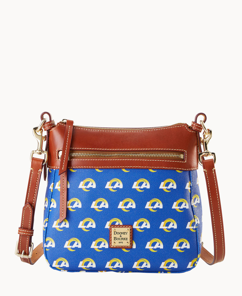 A blue crossbody bag with brown leather accents and gold hardware, featuring a repeating yellow and white Los Angeles Rams logo and a front zipper pocket. The Dooney & Bourke logo is on a leather patch.